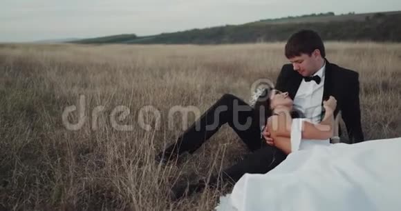 迷人的新娘和新郎在风景中放下新娘触摸浪漫的脸视频的预览图