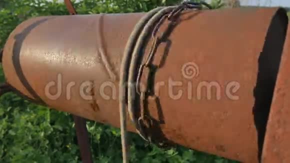 女人用水桶把链条滴到乡村井里打水老式水井连锁关闭旧的生锈的链子视频的预览图