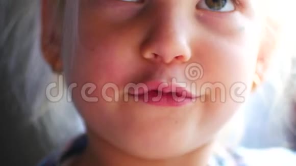 漂亮的女孩做鬼脸可爱的金发孩子棕色的眼睛闭合视频的预览图