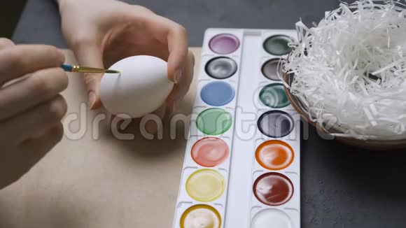 一家人在餐桌上油漆和装饰复活节彩蛋视频的预览图