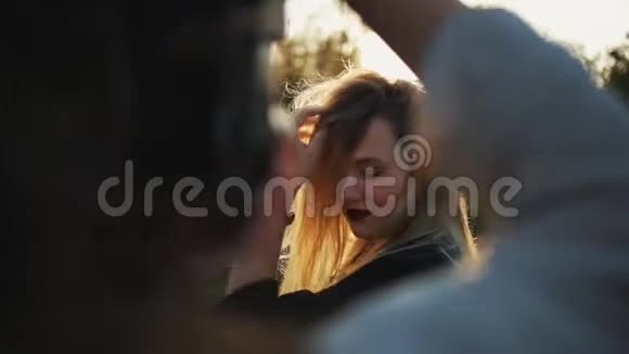一个摄影师在外面拍摄一个美丽的金发女孩的特写镜头视频的预览图