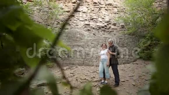 一对老夫妇站在岩石的背景上视频的预览图