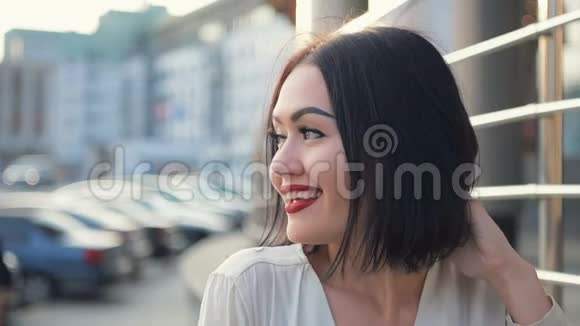 红唇白笑的美女画像闭上微笑的女人摸着长长的黑发开心的脸视频的预览图