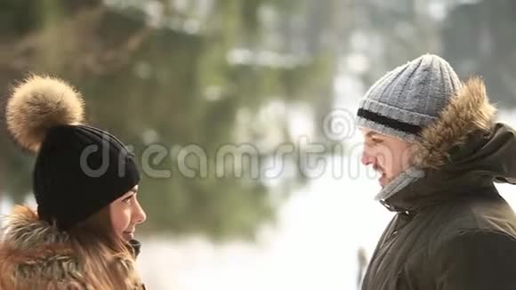 美丽的年轻夫妇花时间在冬季公园圣诞节的气氛男孩和女孩彼此相爱他们穿着视频的预览图