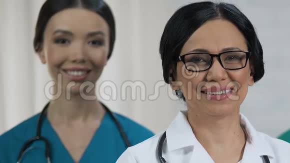 友好的女医务人员对着镜头微笑医疗系统专业视频的预览图