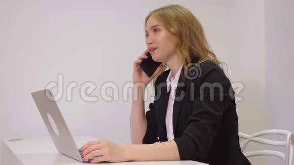 快乐商务女性在办公室用手机进行商务对话视频的预览图