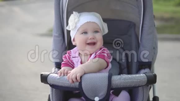 小婴儿笑着坐在婴儿马车里慢动作中镜头视频的预览图