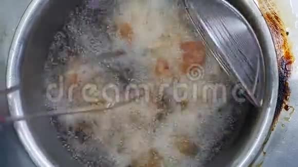 面包鸡在一个深油炸锅里烹饪里面装满了热的冒泡的植物油在当地的街头市场4k视频的预览图