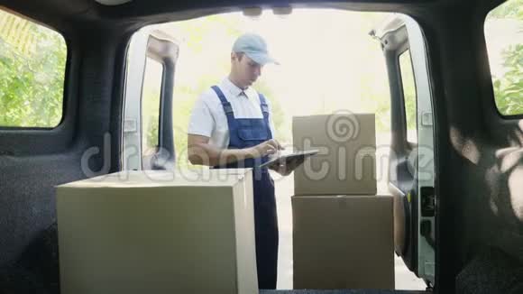 快递员用一台数字平板电脑站在货车旁边视频的预览图