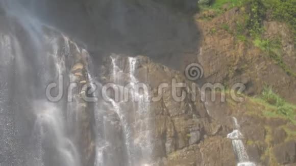 从棕色的岩石后面可以看到湿石瀑布视频的预览图