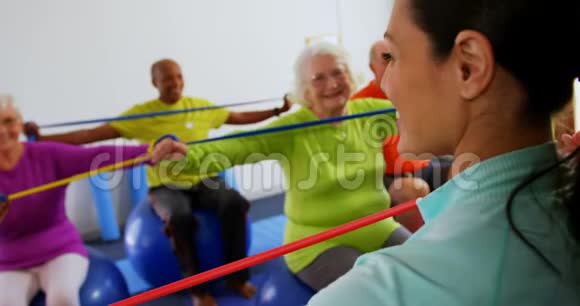 女教练在健身馆4k训练高级健身人员的后视图视频的预览图