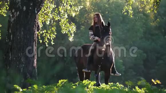 在绿色森林的背景下一个穿着驴的女骑手一大早就下了马视频的预览图