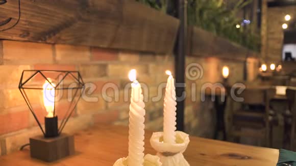 晚餐桌上燃着白色的蜡烛在晚上的餐厅里进行浪漫的约会为浪漫晚餐点燃蜡烛视频的预览图