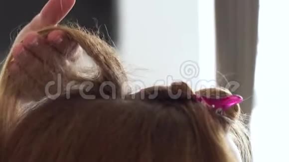 理发师为长头发的女人做卷发使用梳子的发型师视频的预览图