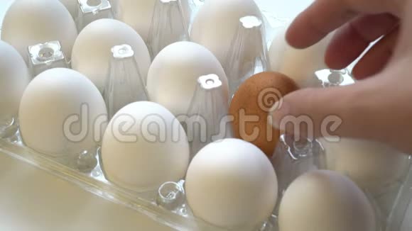 雌性手选择盒子里的孤独的棕色鸡蛋和白色的差异概念个性视频的预览图