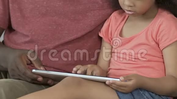 单身父亲解释女儿如何使用平板电脑玩游戏做作业视频的预览图