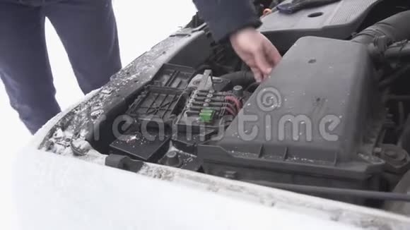 一个人安装一个汽车电池并收紧终端冬天雪电池放电特写慢动作开始视频的预览图