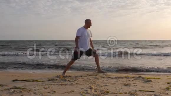 日出时运动员在海滨练习伸展侧角瑜伽视频的预览图