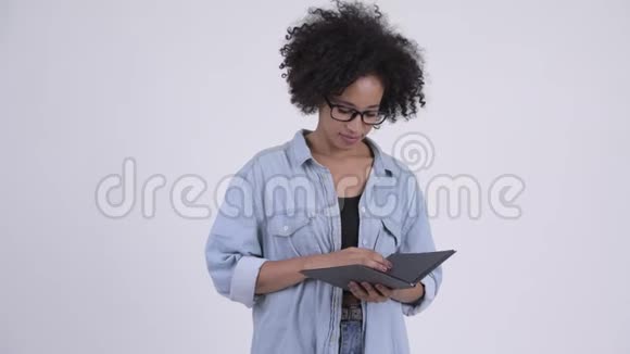 年轻漂亮的非洲女人戴着眼镜脸上戴着书视频的预览图