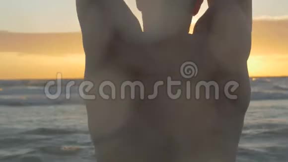 勇肌肉男在海滩上热身因为海浪在后面坠毁4k视频视频的预览图