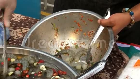 泰国辛辣海鲜沙拉与虾鱿鱼螃蟹和草药在街头食品视频的预览图