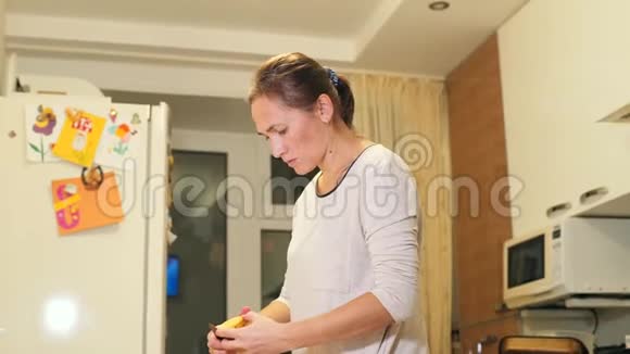 在家庭厨房里剥土豆一个女人拿着刀剥土豆在碗里打扫烹饪食物视频的预览图