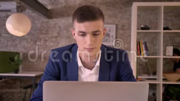 年轻有魅力的商人用笔记本电脑工作在窗户里看做梦的概念交流的概念视频的预览图