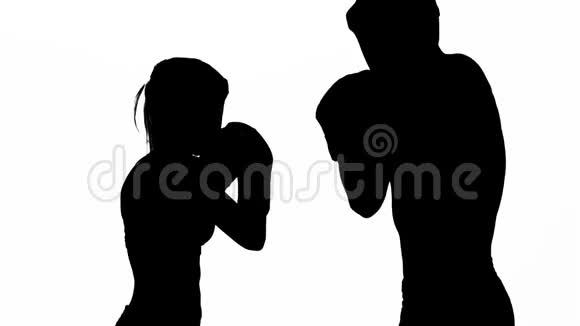 戴着女拳击手套的男人在拳击场上打剪影白色背景慢动作视频的预览图