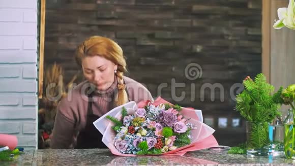一个女花店选择一条丝带来装饰一束花视频的预览图