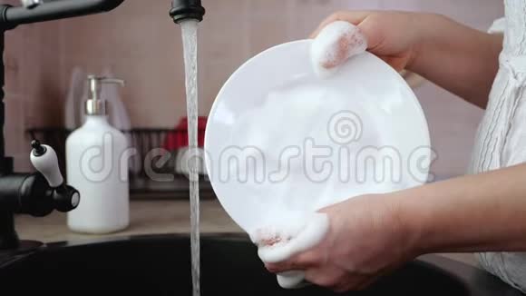 女人用手在厨房水槽冲洗盘子慢动作视频的预览图
