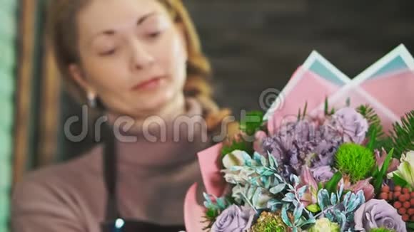 带着美丽花束的女人花店前景中的花束背景模糊视频的预览图