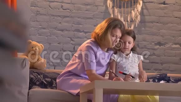 母亲和她的小女儿做家庭作业父母帮助孩子学习家庭观念在室内视频的预览图