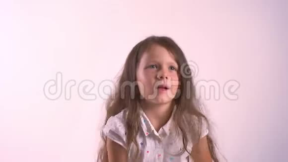 小可爱的女孩抱着她的毛绒玩具熊站在粉红色的工作室背景上视频的预览图