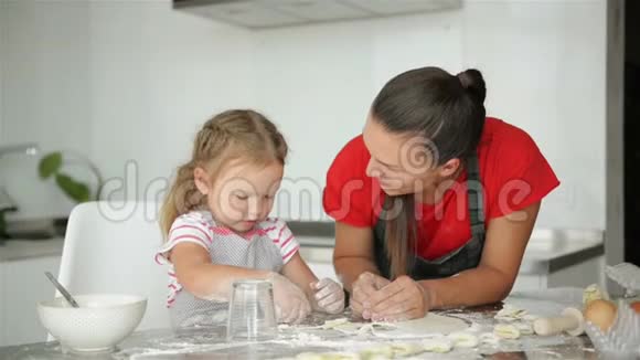 小支持者正在帮助她的母亲做饭母亲教她的女儿如何准备面团视频的预览图