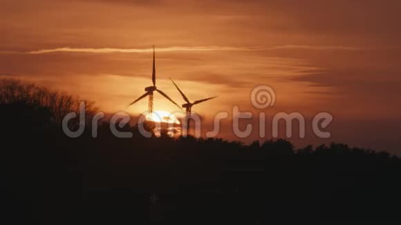 两个风力涡轮机在日落后的森林视频的预览图