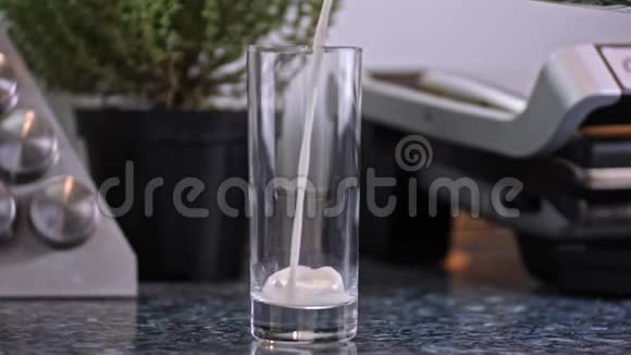 厨房里的牛奶冷饮倒入低杯中的慢速特写镜头视频的预览图
