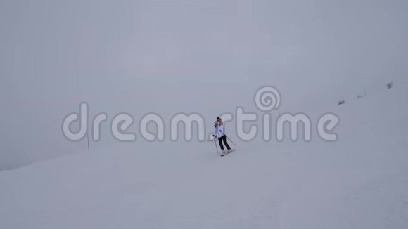 冬季假日两名运动女滑雪运动员在山下滑雪视频的预览图