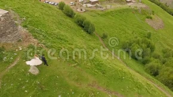 新婚夫妇坠入爱河沿着一条狭窄的小径下山格鲁吉亚卡兹贝吉视频的预览图