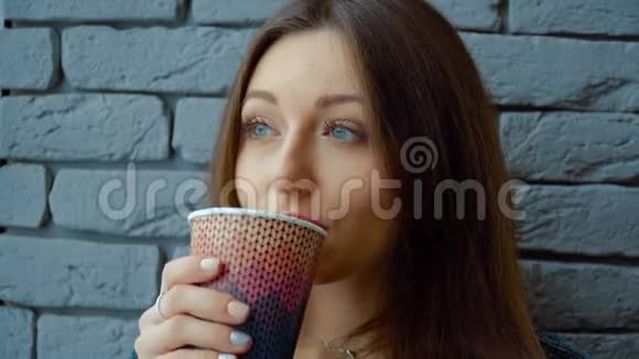 咖啡馆里的女孩从纸杯里喝热巧克力视频的预览图