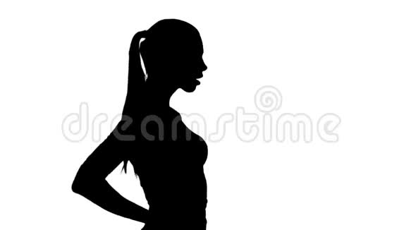 剪影美丽的黑发女孩走路双手在臀部视频的预览图
