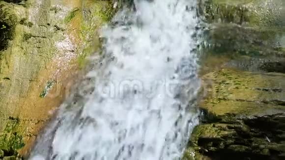 天然瀑布上的绿色石头特写视频的预览图