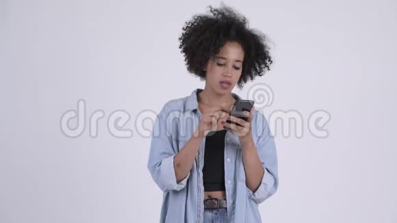 年轻快乐的非洲女人用电话得到好消息视频的预览图