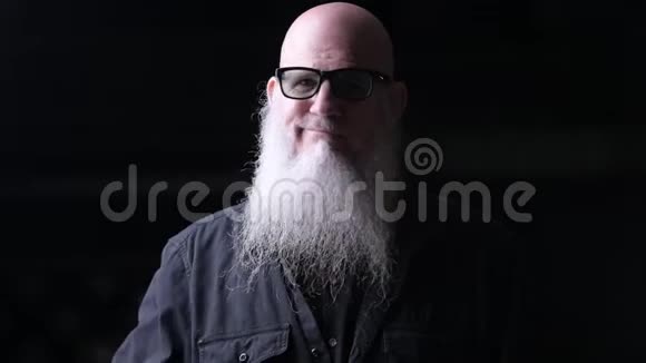秃头男子夜间用梳子梳灰胡子的画像视频的预览图