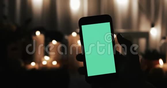 男性手拿着绿色屏幕的智能手机很少有运动类型向右滑动和敲击点燃了蜡烛视频的预览图