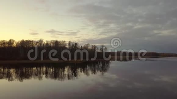清晨无人机空中飞行秋日日出水面和森林反射视频的预览图