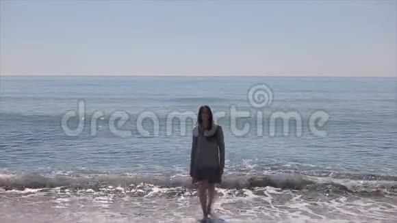 一个美丽的女孩走出大海停下来用一只手臂拥抱自己慢动作视频的预览图