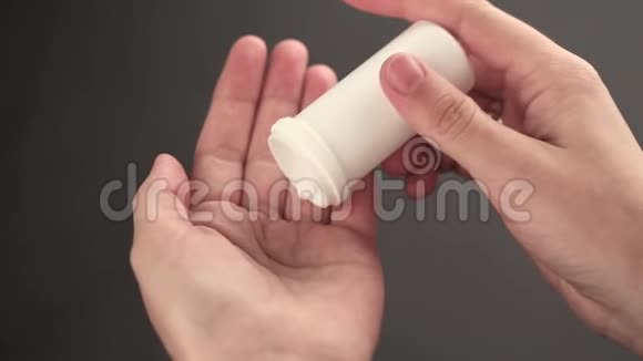 从罐子里倒入一只手的药丸视频的预览图