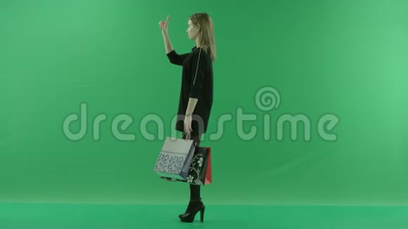 带包的年轻女性触摸增强现实中的虚拟屏幕彩色关键绿色背景视频的预览图