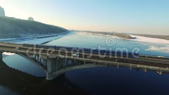 冬季乘坐桥上铁路过河公路的地铁鸟瞰图视频的预览图