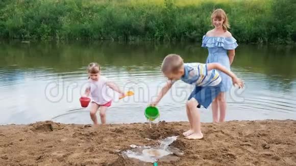 小朋友夏天在河里玩一个女孩和一个男孩正在建一条小溪妈妈在照顾婴儿的时候视频的预览图